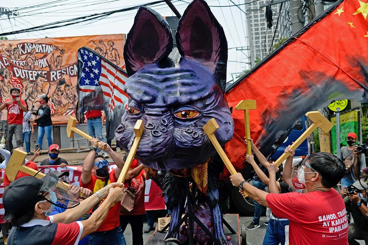 Teilnehmer einer 1. Mai-Demonstration in Quezon-Stadt schlagen auf ein Fabelwesen ein, das den Präsidenten Duterte darstellt