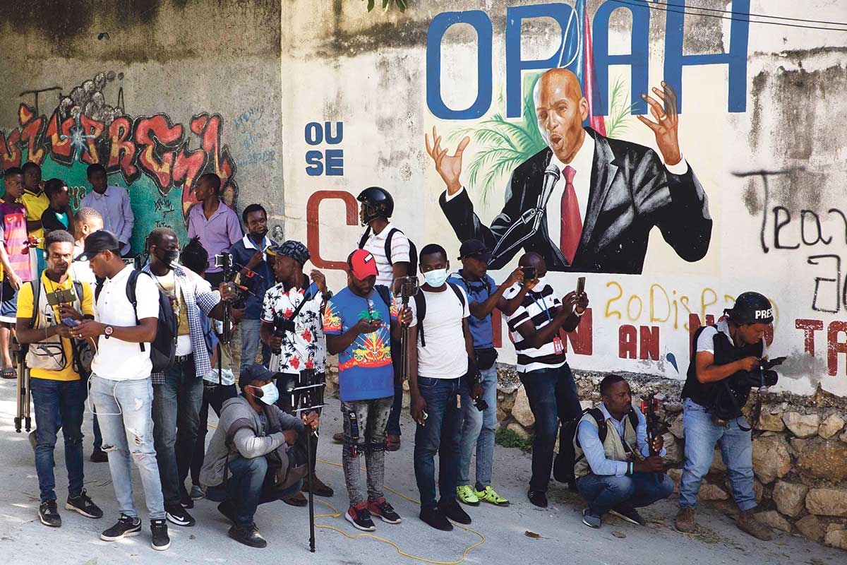 Haitianische Journalisten vor einem Wandbild von Präsident Jovenel Moïse nach dessen Ermordung