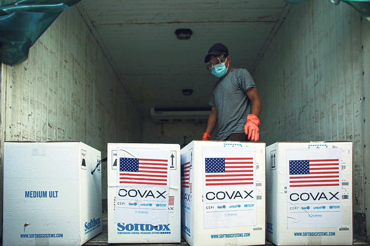 Covax Lieferung, Person in einem LKW mit vier großen Kisten