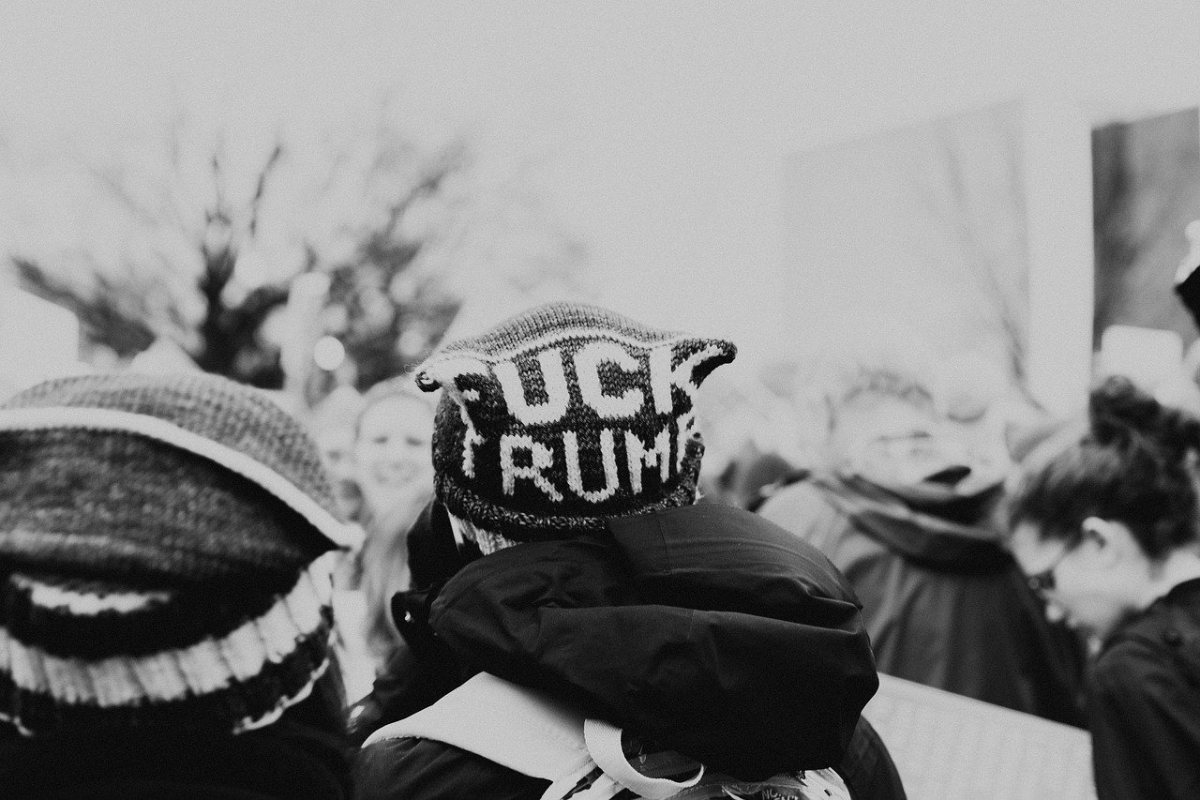 Mütze in Menschenansammlung mit Text "Fuck Trump"