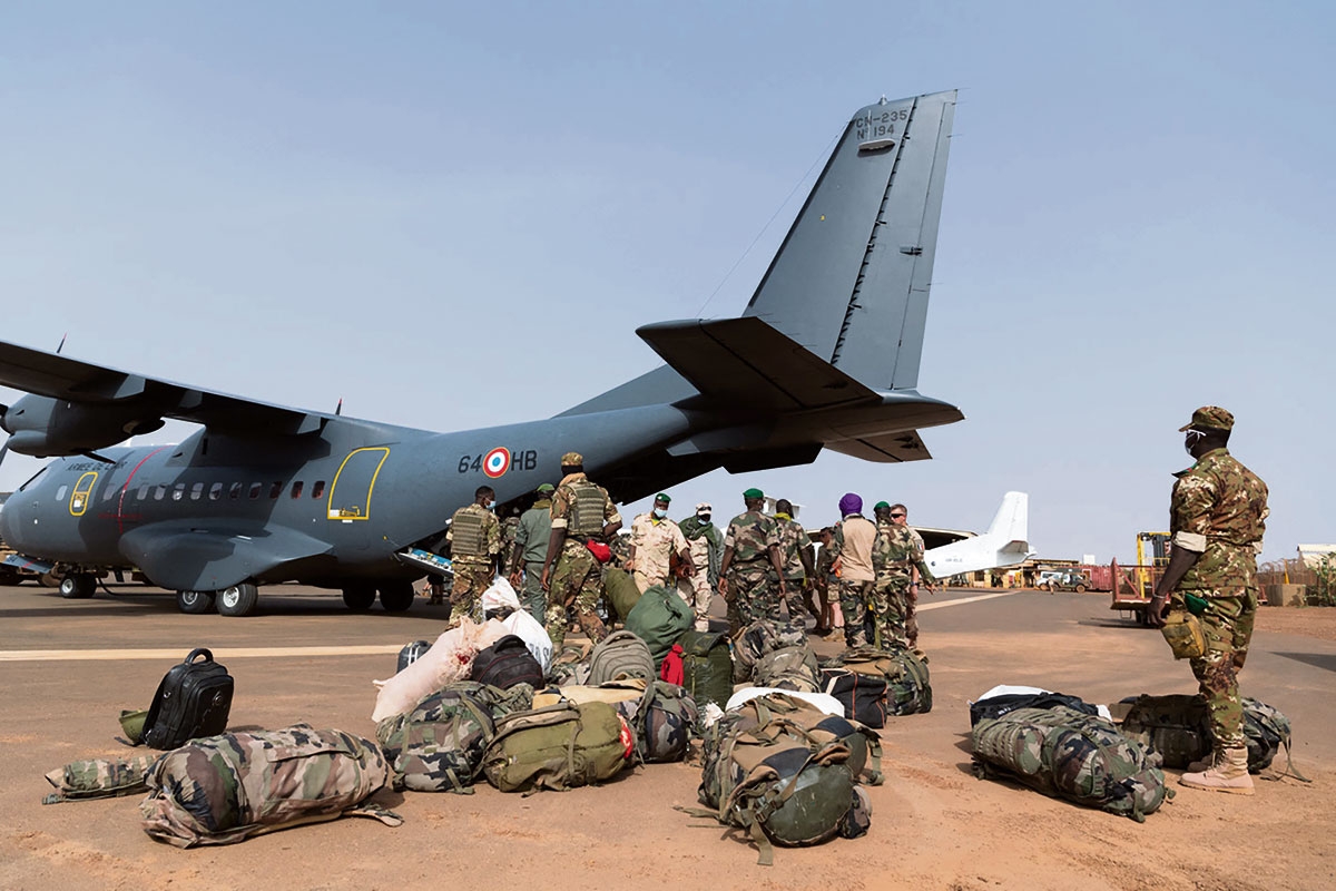 Soldaten mit Gepäck vor einem Flugzeug