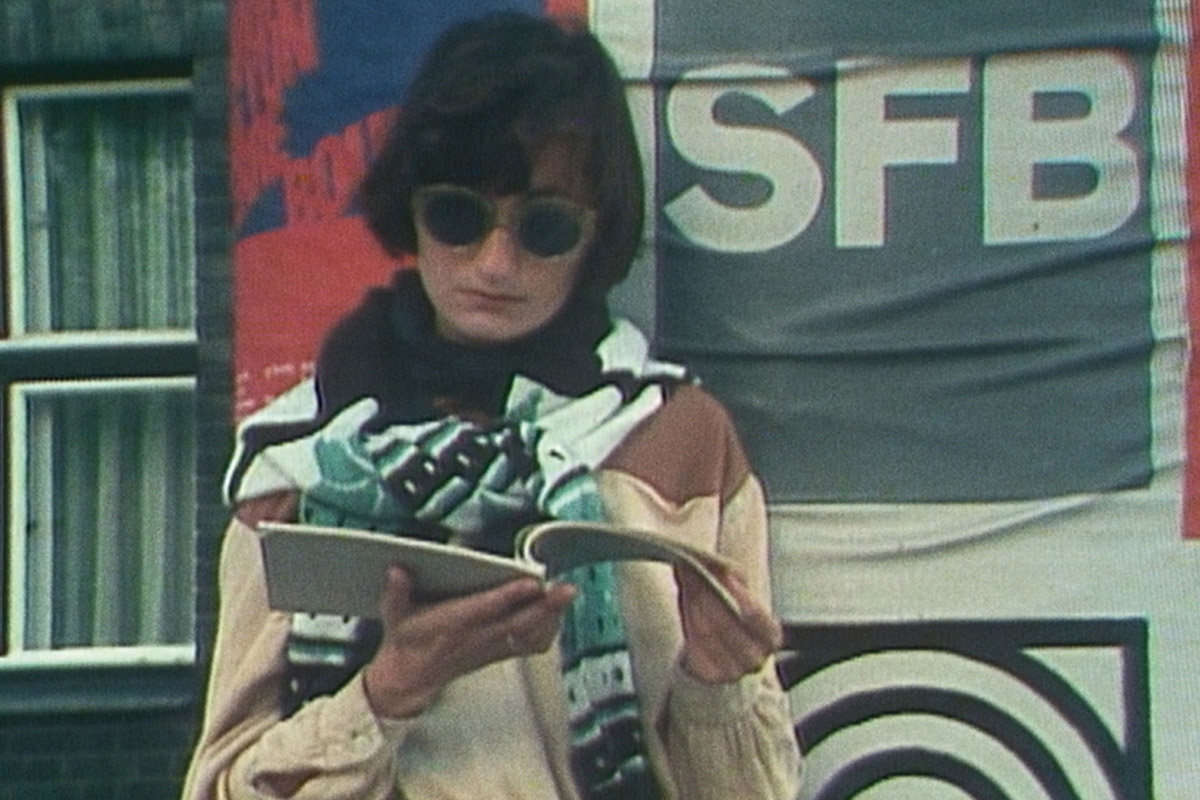 Elfriede Jelinek mit Sonnenbrille liest in einem Heft