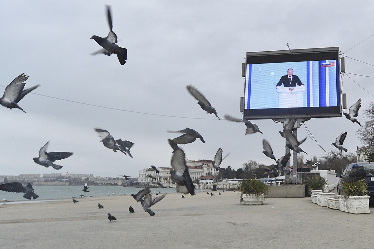 Putins Rede wird auf einem Bildschirm am Hafen übertragen
