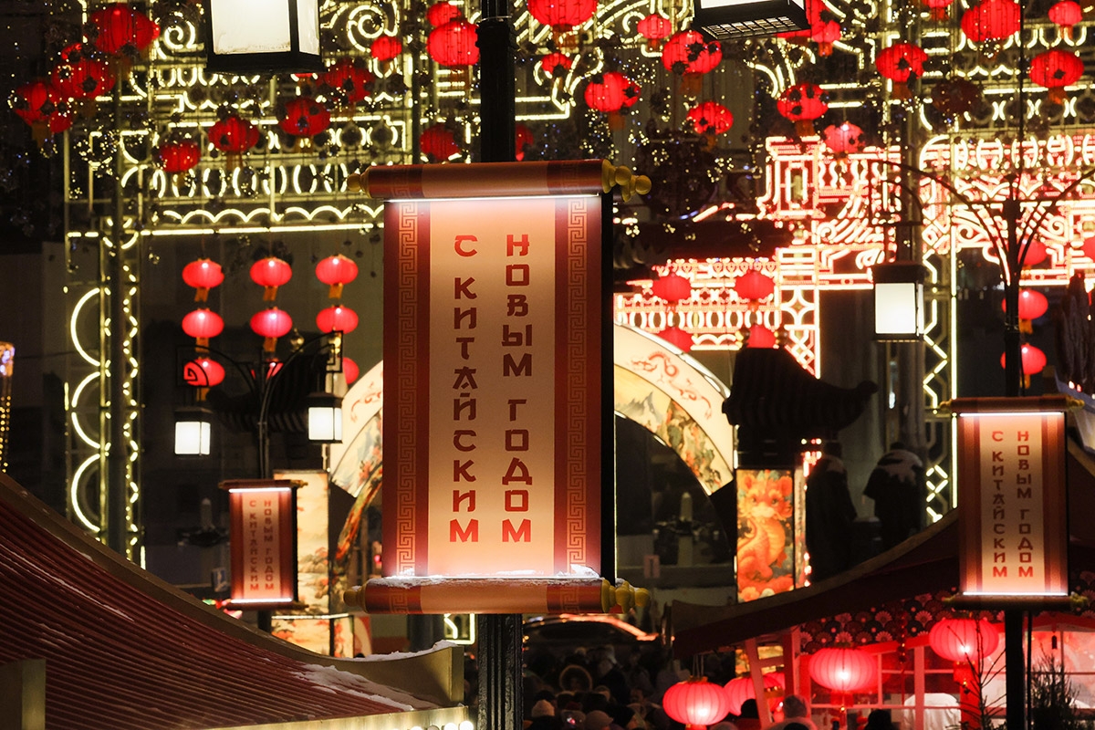 Festlich rot dekorierte Innenstadt. Ein Schild mit der Aufschrift »Frohes Chinesisches Neujahr« in der Moskauer Kamergerskij-Gasse, 9. Februar