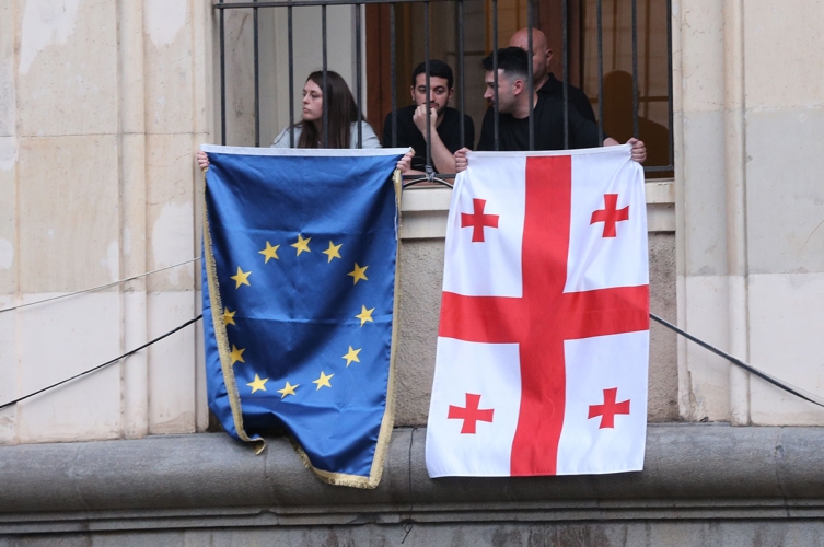 Protestierende zeigen neben der georgischen auch die EU-Fahne. Tiflis, 1. Mai
