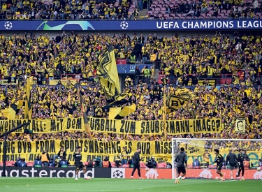 Dortmund-Fans mit einem Spruchband "Rheinmetall: Mit dem Fußball zum Saubermann-Image?"