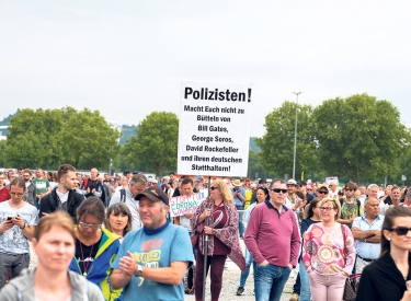 Antisemitisches Erklärungsmodell. Zu jener Elite, die vermeintlich die Welt regiert, zählt diese Demonstrantin auch den jüdischen Investor George Soros, Stuttgart, 9. Mai