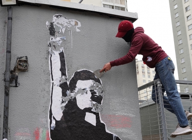 Arbeiter entfernt ein Wandbild in Minsk