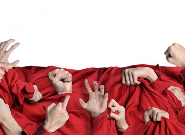 Viele Hände in verschiedenen Posen vor einem roten Tuch