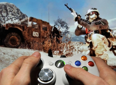Hände mit Contoller im Hintergrund das Videospiel Call of Duty