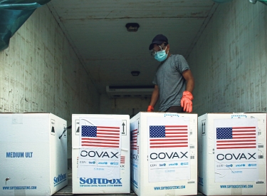 Covax Lieferung, Person in einem LKW mit vier großen Kisten