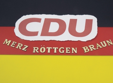Auf einer Deutschlandfahne befindet sich ein CDU Logo und die Kandidaten fuer den Vorsitz der CDU