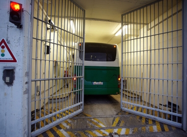 Bus hinter sich schließendem Gefängnistor