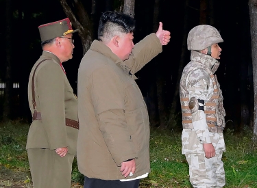 Kim Jong-un mit zwei Soldaten zeigt seinen Daumen