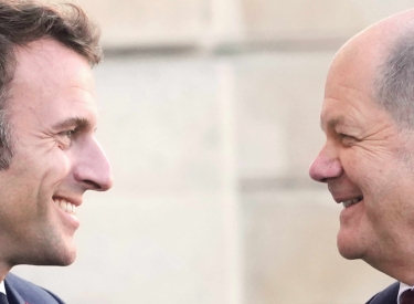 Emmanuel Macron und Olaf Scholz lächeln einander an