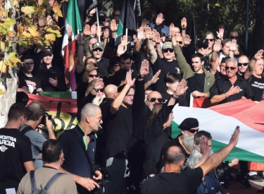 Dunkle gekleidete Demonstranten zeigen den faschistischen Gruß