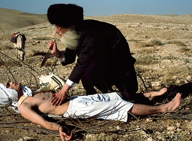 Ein Mann mit Turban sticht auf einen am Boden Liegenden ein