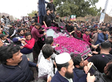 Ein mit Blumen übersähtes Auto inmitten einer Menschenmenge