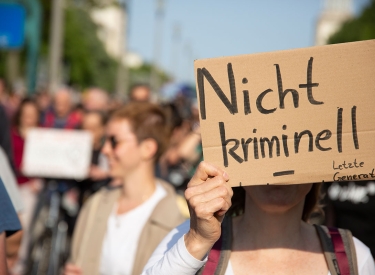 Handgemaltes Schild mit der Aufschrift "nicht kriminell" bei einer Demo der Unterstützer der Klimaaktivisten von Letzte Generation