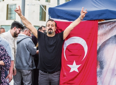 Vor einer Wahlstelle für die türkische Präsidentschaftswahl in München zeigt ein Anhänger Recep Tayyip Erdoğans das Zeichen der »Grauen Wölfe«