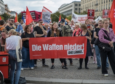 Janine Wissler, Bundesvorsitzende der Linkspartei, hinter Linkspartei-Transparent: »Die Waffen nieder!«