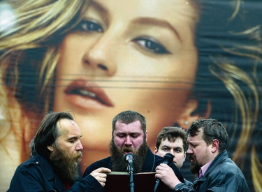 Aleksandr Dugin (l.) und Mitstreiter auf einer Veranstaltung in Moskau, 8. April 2007, im Hintergrund Werbung mit Gisele Bündchen
