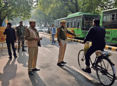 Erhöhte Sicherheitsvorkehrungen. Ein Polizist hält einen Radfahrer vor dem Parlament in Delhi an, 13. Dezember