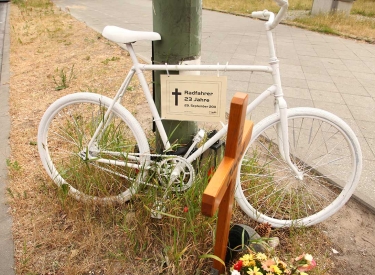 Ein sogenanntes "Geisterrad" steht neben Blumen und einem Kreuz auf einer Verkehrsinsel in Berlin im Bezirk Friedrichshain/Kreuzberg im Mai 2012.